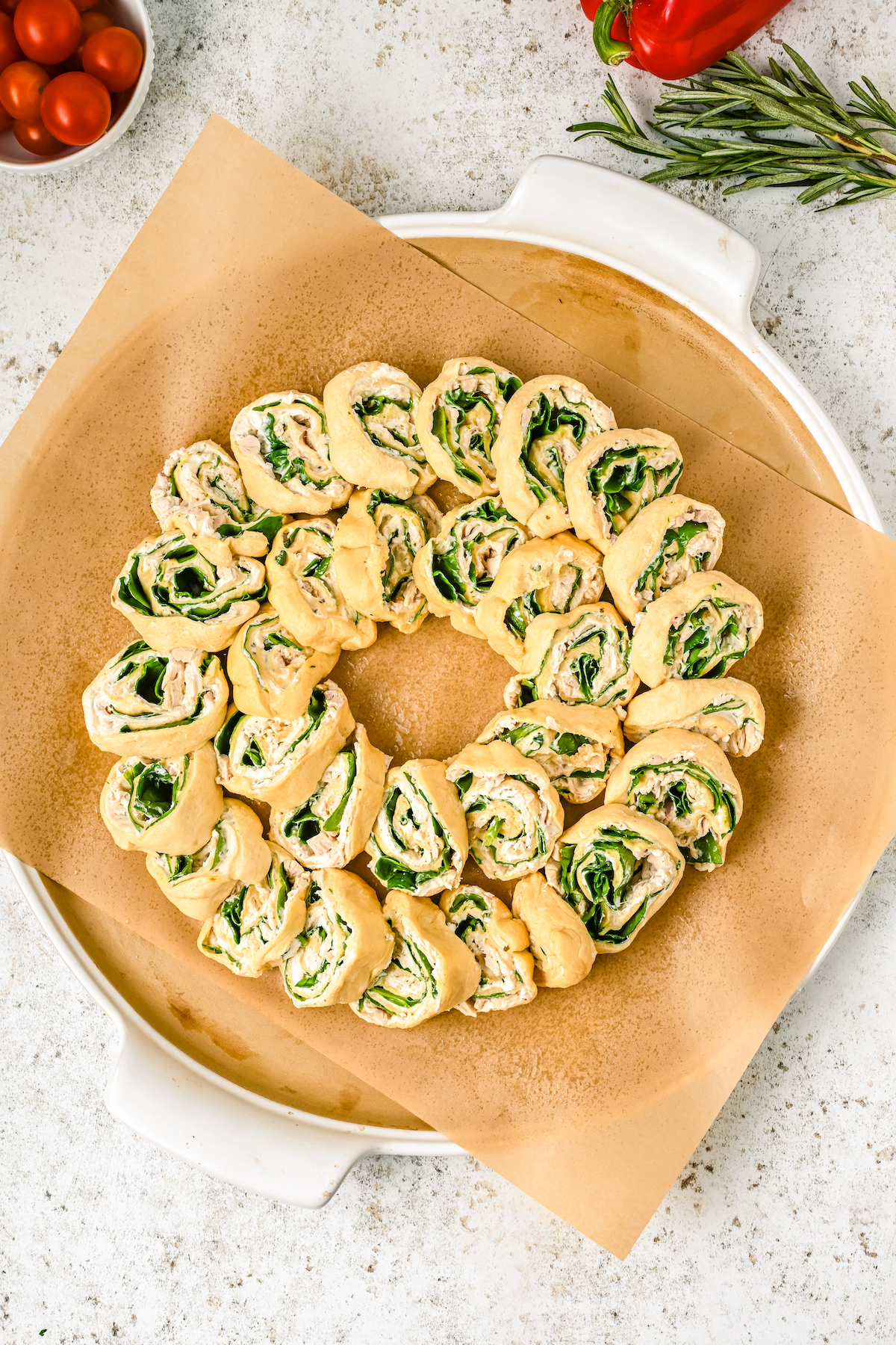 Overlapping crescent roll spirals on a parchment-lined baking sheet.
