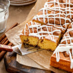 A slice of cinnamon roll cake being served with a spatula.