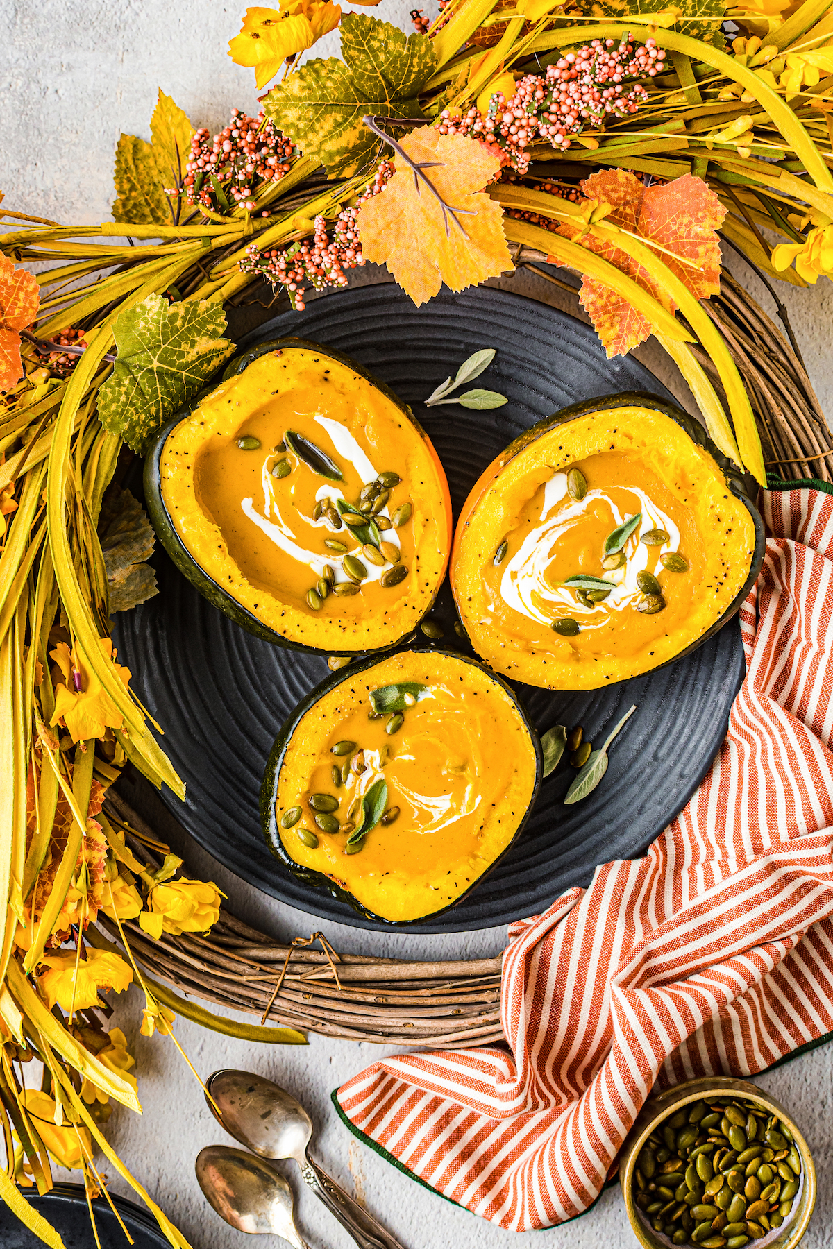 Soup served in acorn squash bowls and topped with pumpkin seeds and sage.