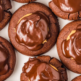 Overhead shot of brownie cookies topped with peanut butter and melted chocolate.