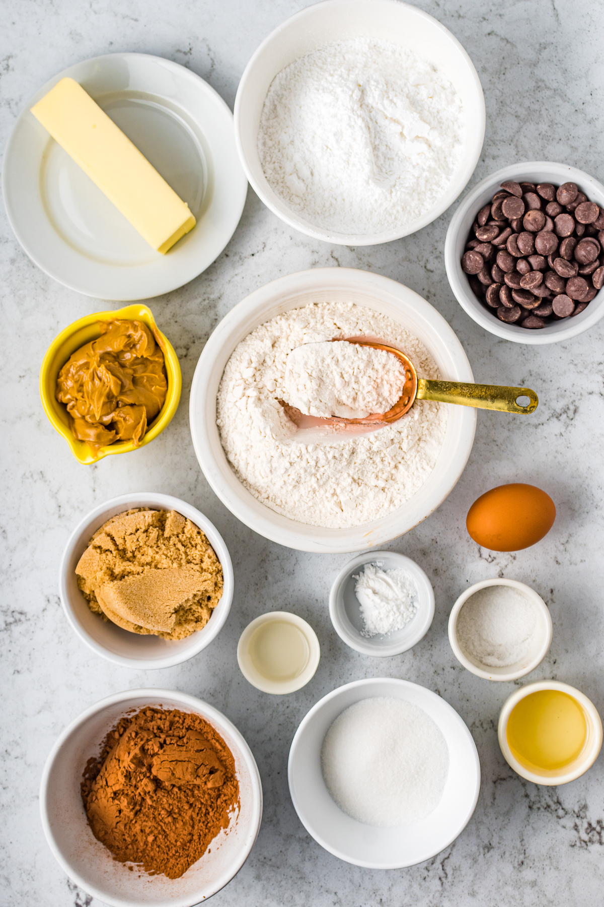 From top left: Butter, sugar, chocolate chips, peanut butter, flour, brown sugar, egg, cocoa powder, powdered sugar, vanilla, baking powder, salt, oil.