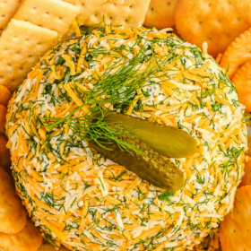 Pickle cheese ball on a tray with crackers.