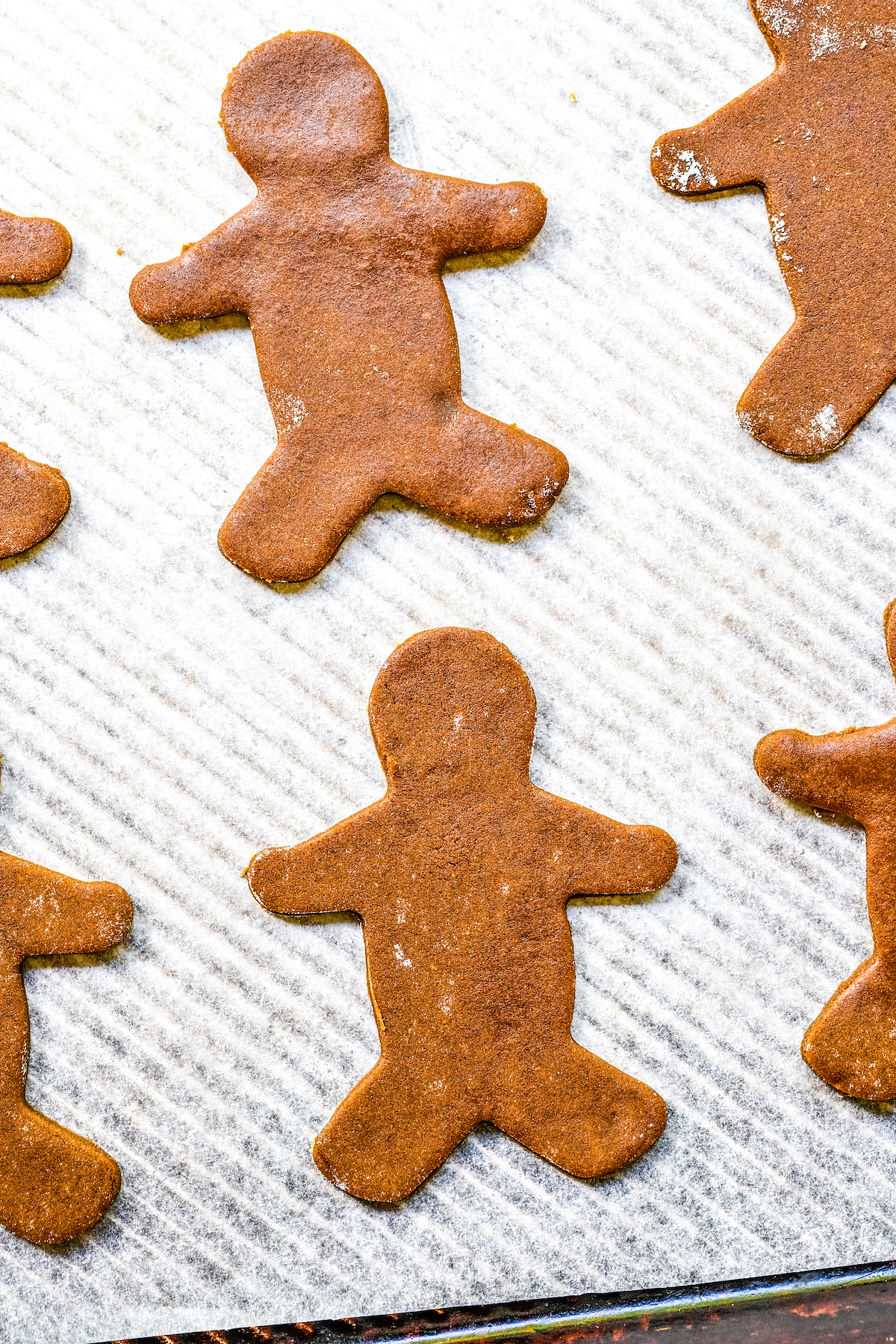 Unbaked gingerbread man cookies on a baking sheet.