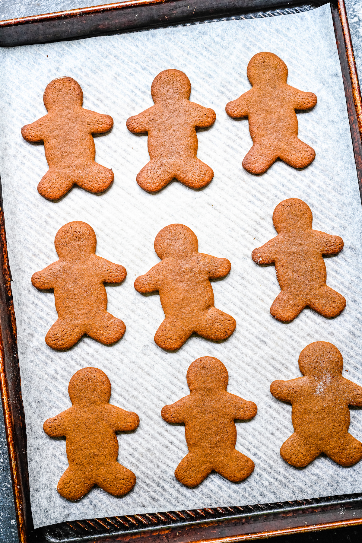 Baked gingerbread man cookies on a baking sheet.