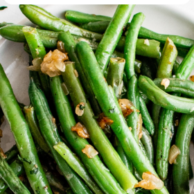 Sauteed green beans with garlic on a plate.