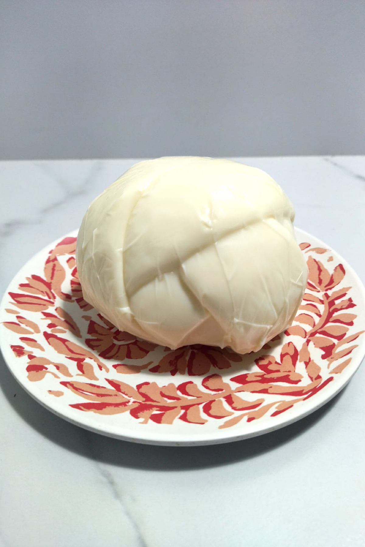 Ball of oaxaca cheese on a plate.