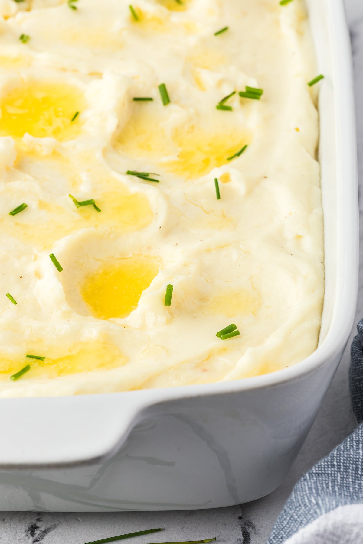 Creamy make-ahead mashed potatoes in a white rectangular casserole.