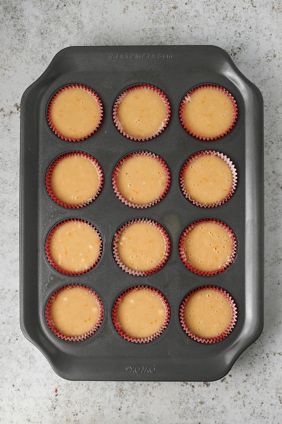 Muffin liners filled with batter.
