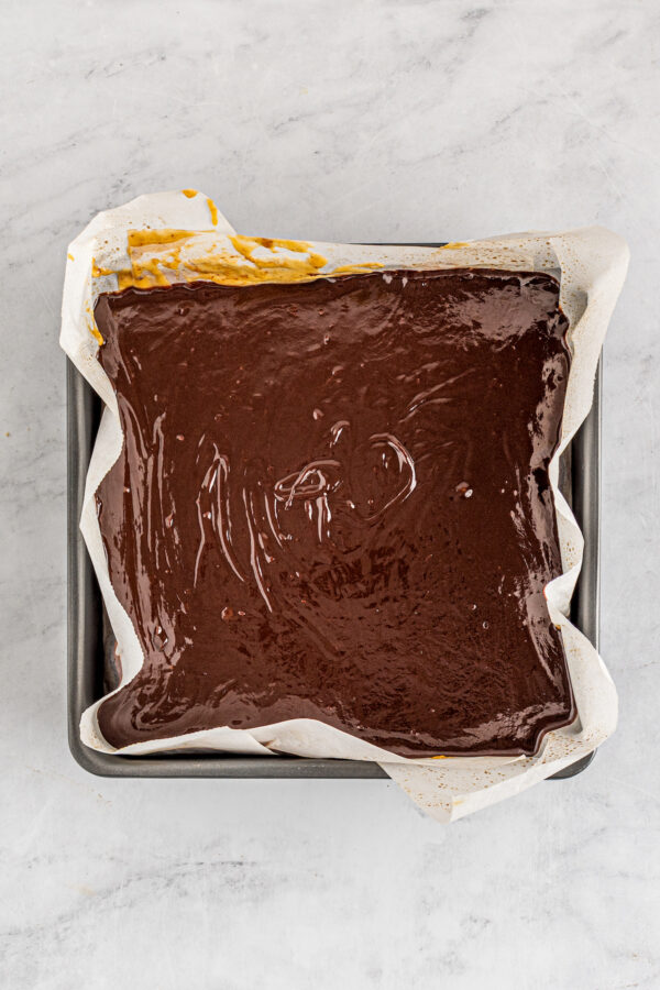 Chocolate poured over other ingredients in a baking dish.