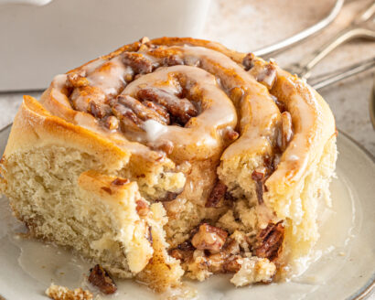 A homemade cinnamon roll with a bite taken from it.