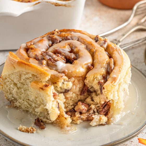 A homemade cinnamon roll with a bite taken from it.