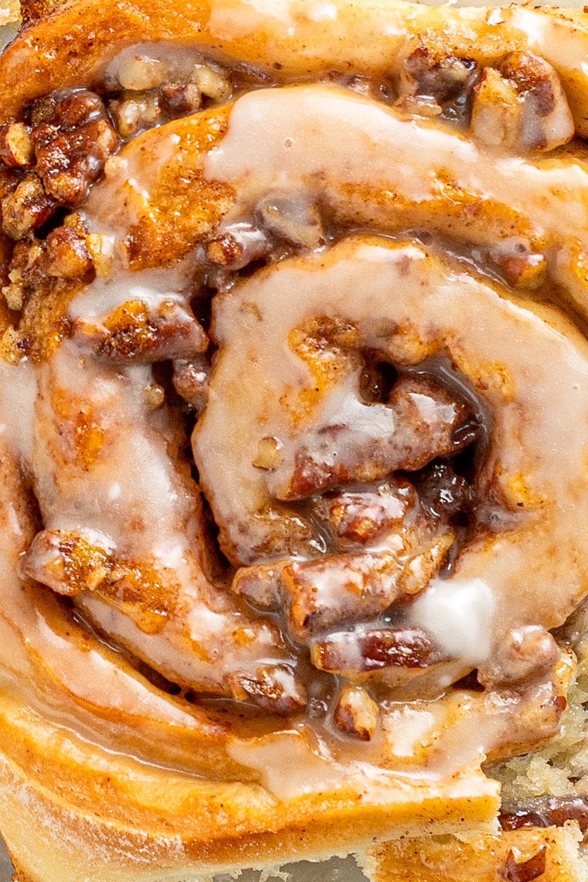 Close-up shot of an iced pecan pie sticky bun.