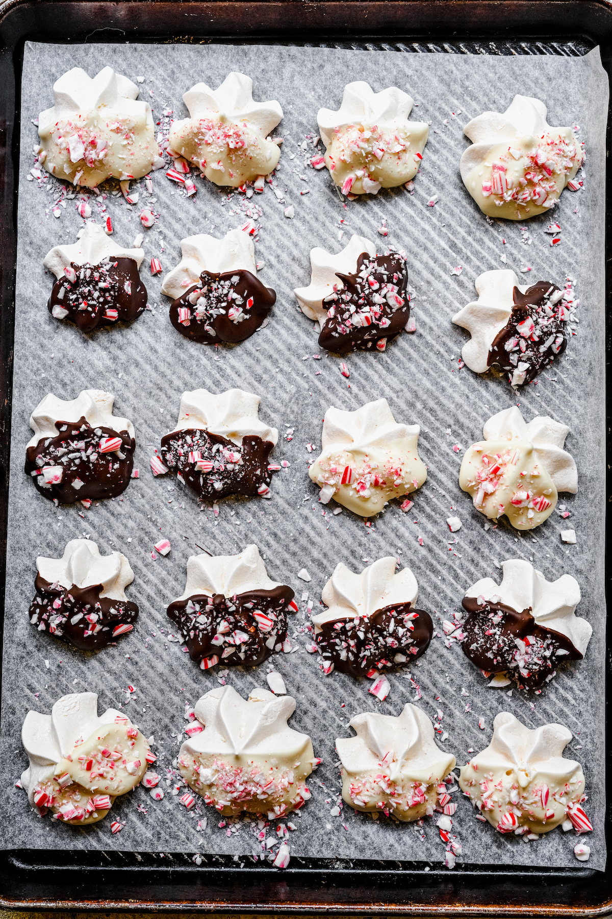 A baking sheet of chocolate and peppermint meringues lined up on a baking sheet.