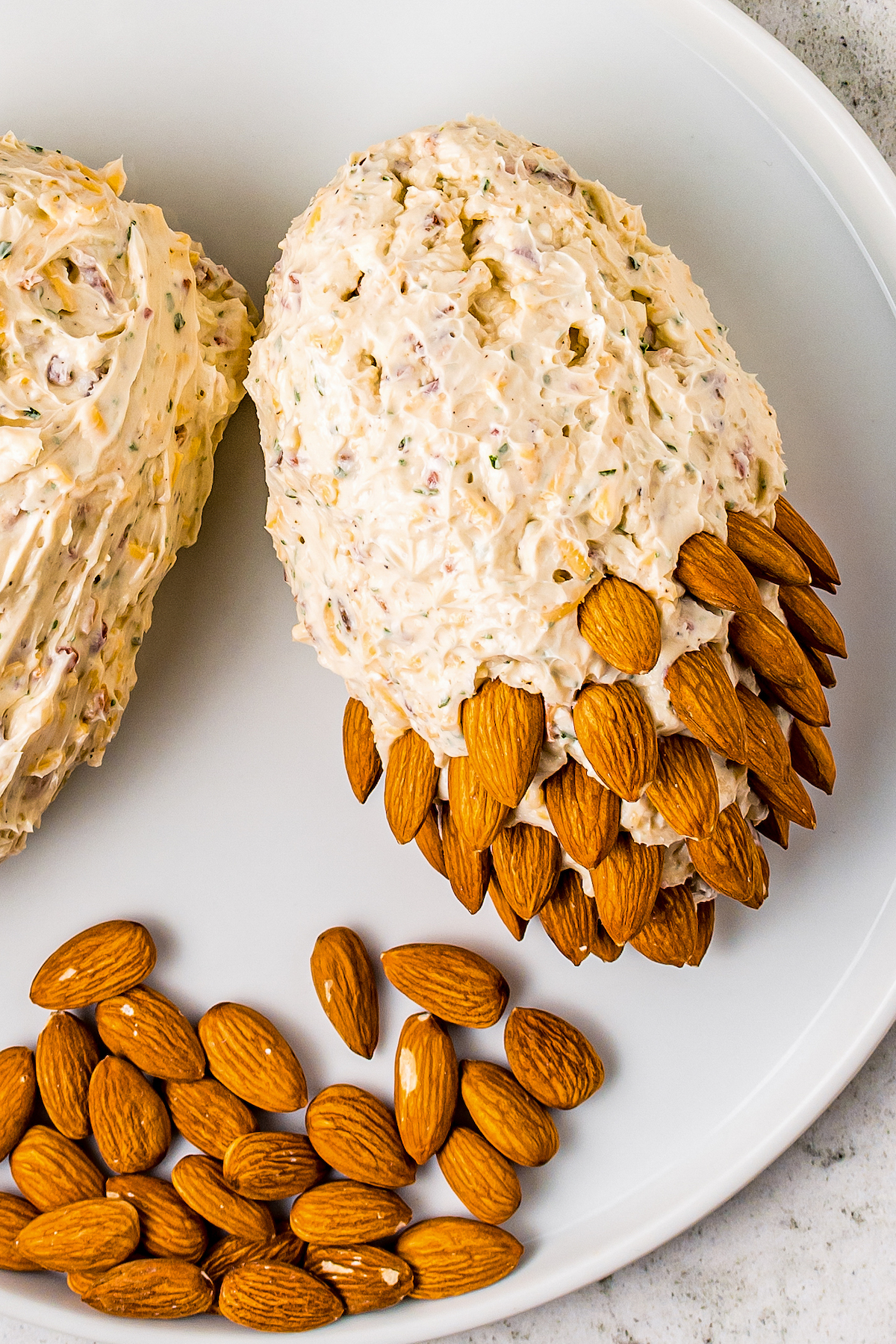 Almonds pressed into a cheese ball, with the pointed ends of the almonds sticking out.