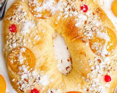 Baked Spanish Roscón de Reyes topped with candied oranges, almonds, and maraschino cherries.