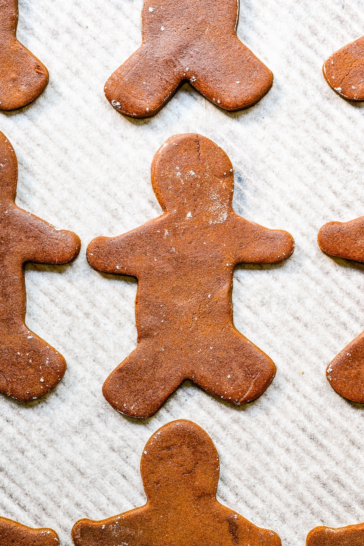 Unbaked gingerbread men on a cookie sheet.