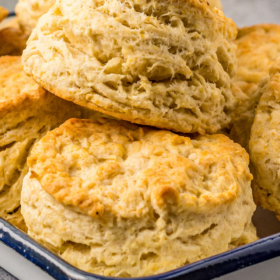 Buttermilk biscuits stacked on top of each other in a baking dish.