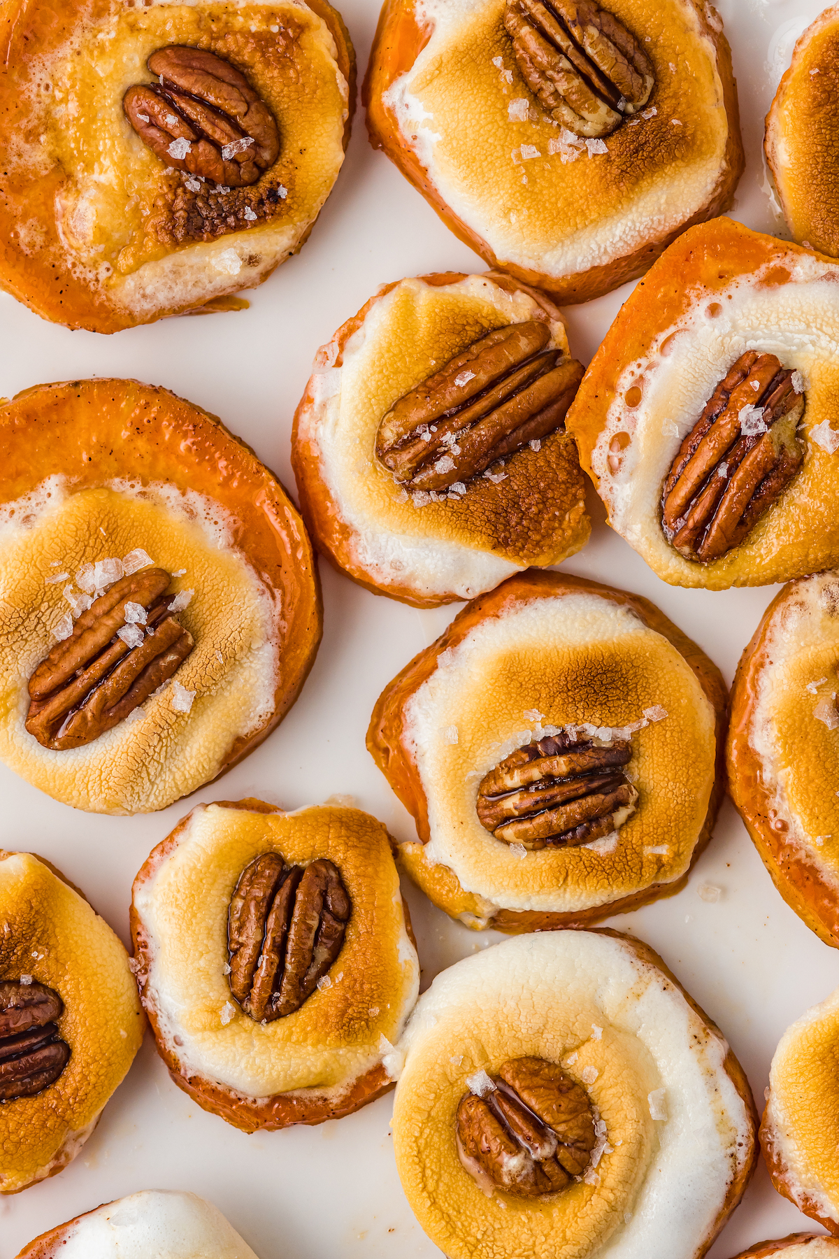 Close-up of baked sweet potato bites with marshmallows and pecans.