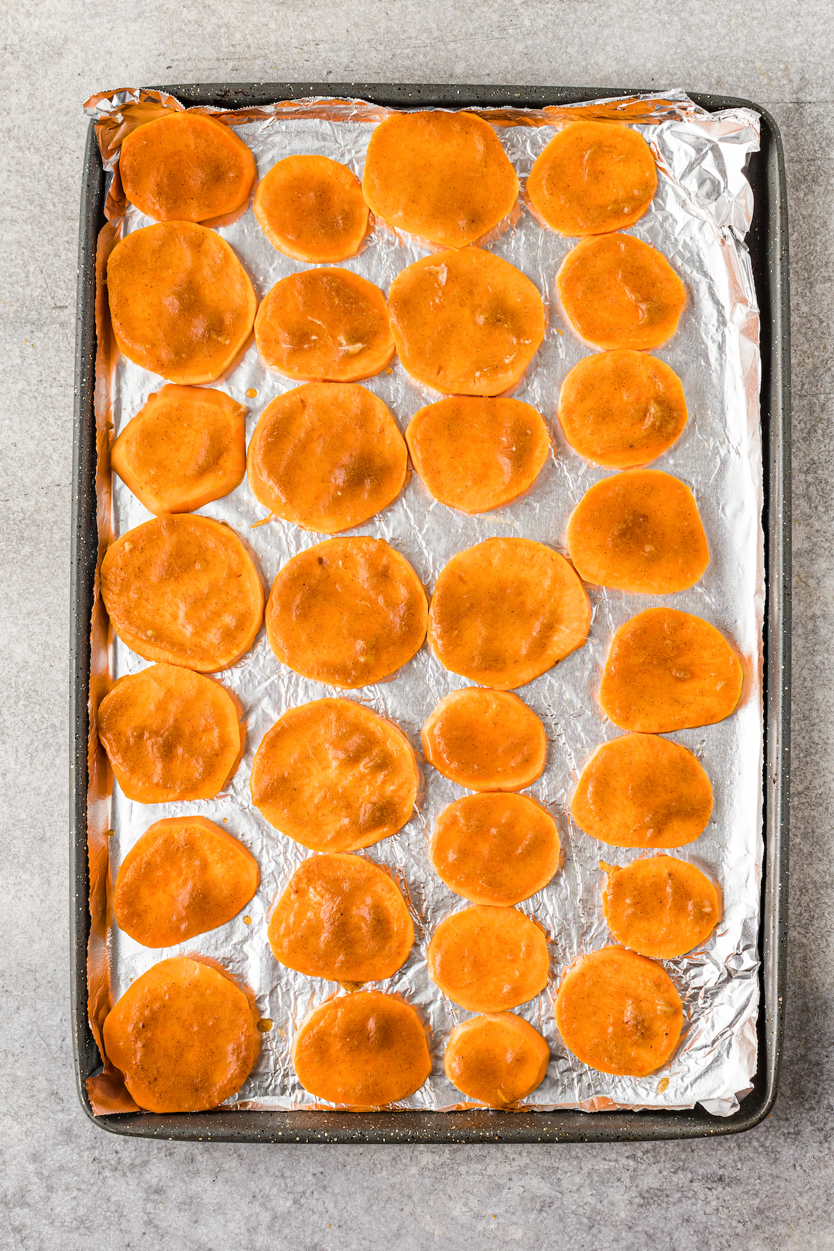 All sweet potato slices with butter-sugar mixture, before baking.