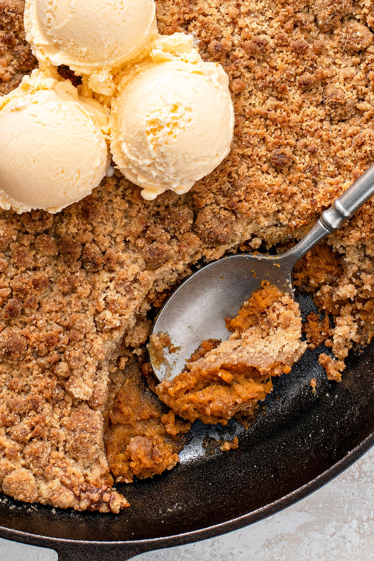 Up close image of spoon scooping up a serving of sweet potato pie crumble.