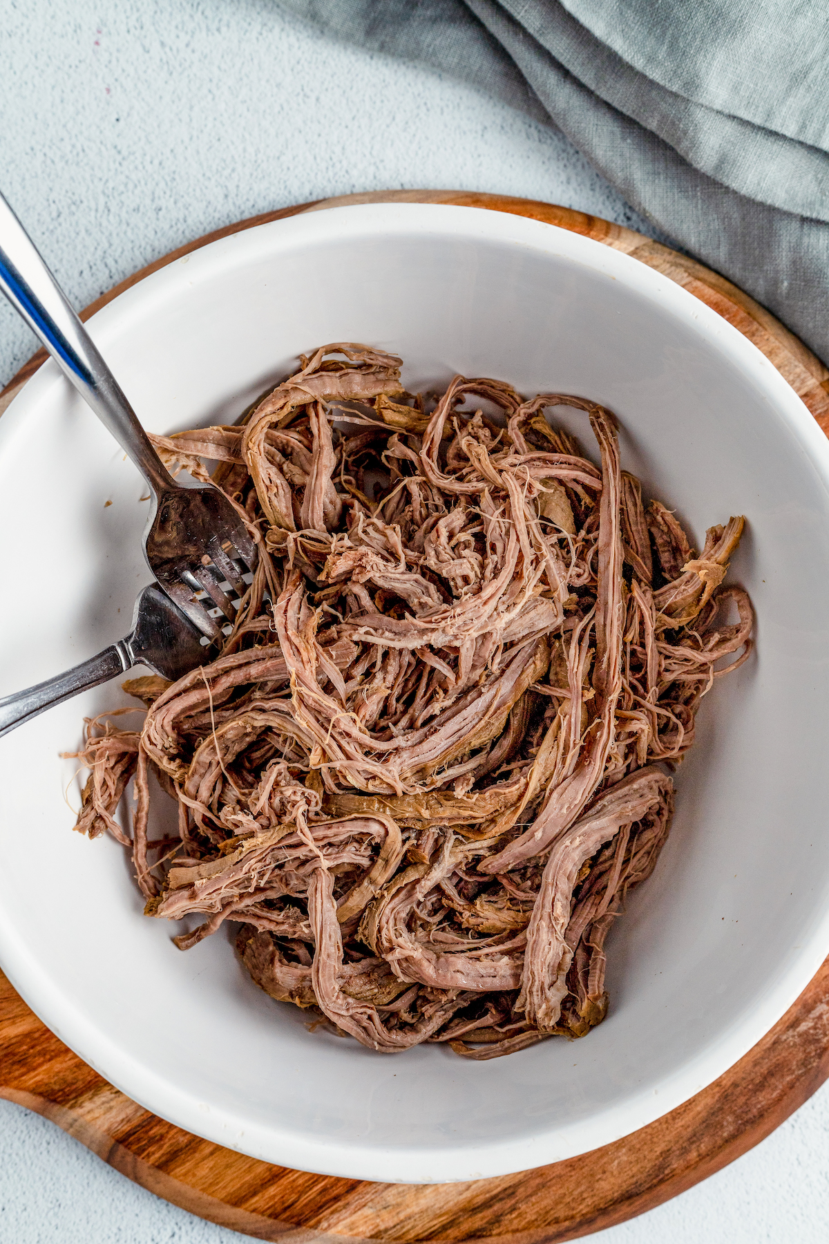 Shredded beef in a bowl with two forks.