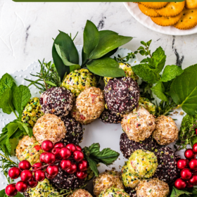 Cheese balls arranged into a wreath with greenery on a platter.