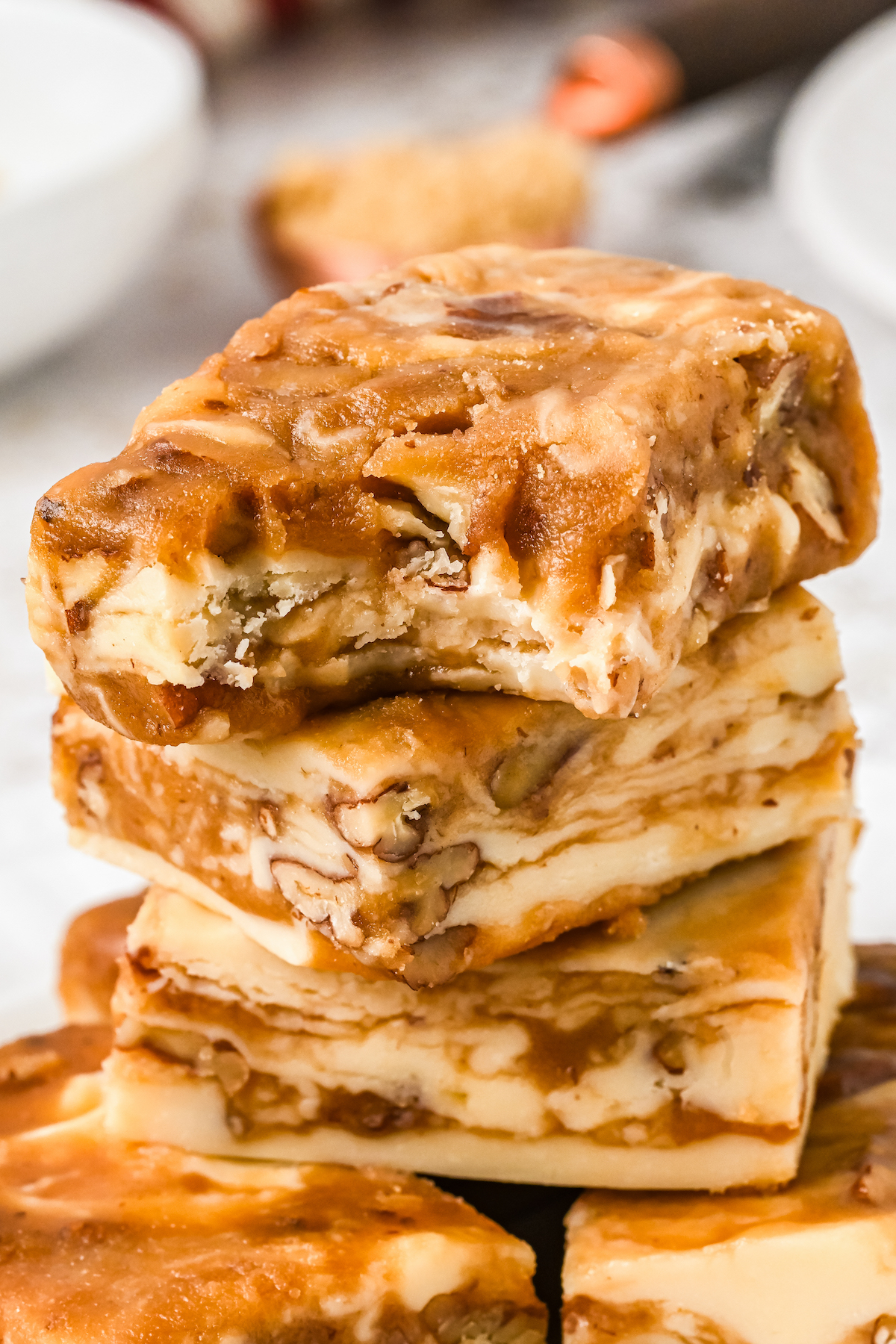 A stack of praline fudge squares, with a bite taken out of the top piece.