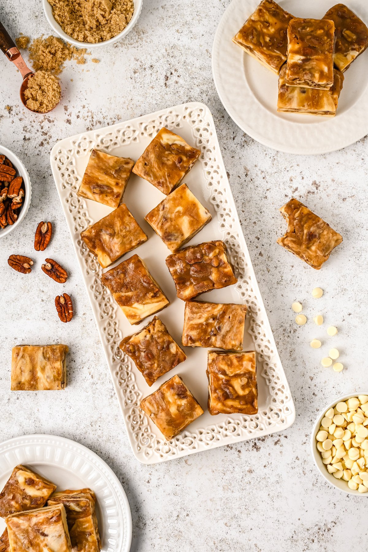 Squares of white chocolate praline fudge on a serving plate.