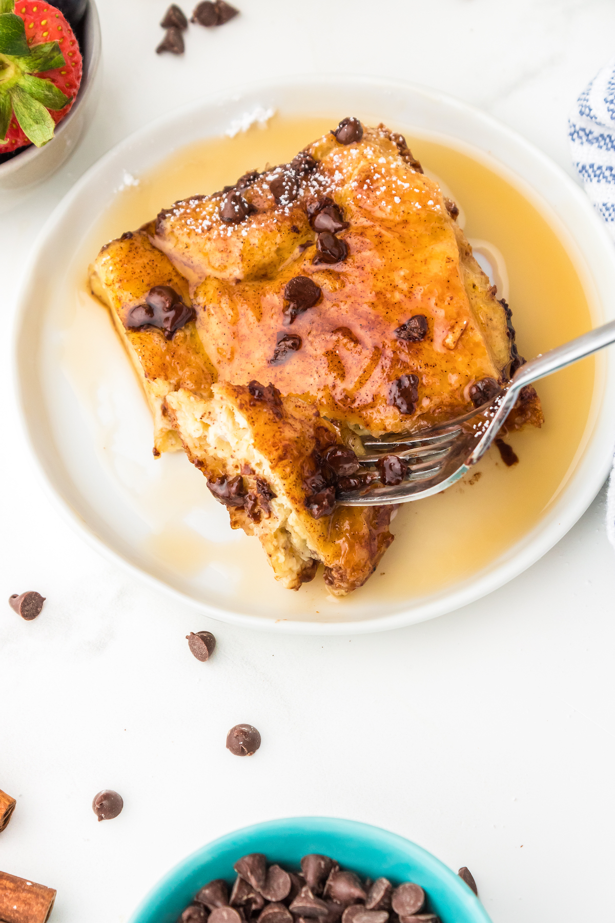 Slice of chocolate chip croissant French toast bake with honey.