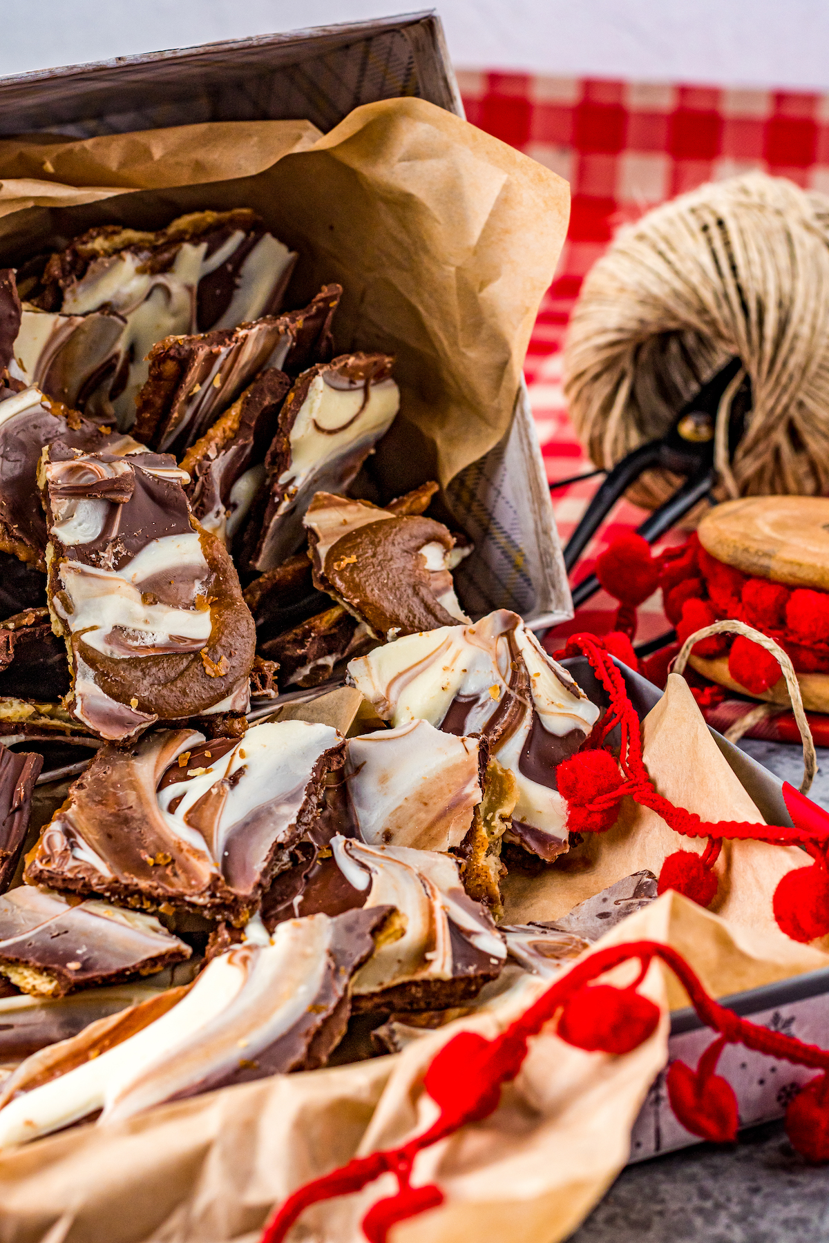Cracker toffee candy with swirled chocolate in a tin lined with parchment paper.
