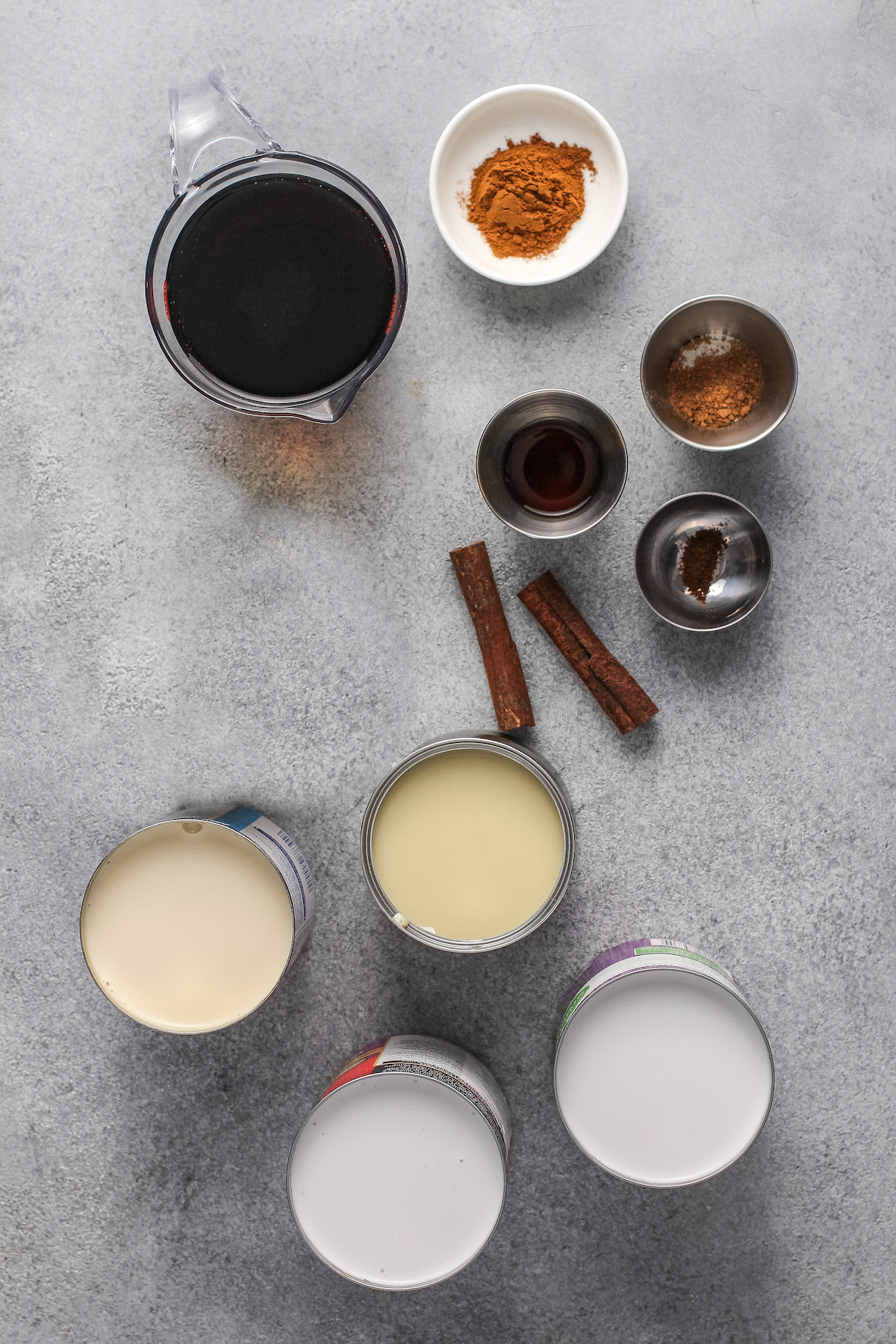 Ingredients arranged on top of a table top with spices in bowls.