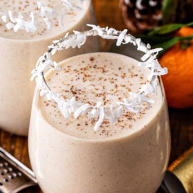 A glass of coconut eggnog with spices on top.