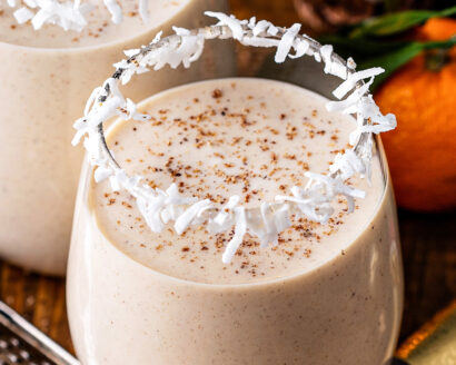 A glass of coconut eggnog with spices on top.