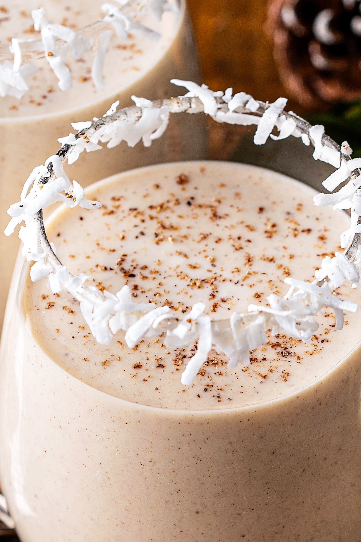 Coquito with freshly grated nutmeg on top in a glass.