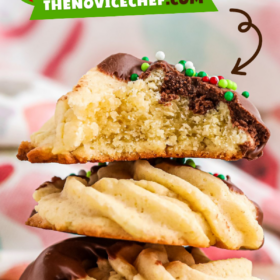 Butter cookies half dipped in chocolate with Christmas sprinkles stacked on top of each other.