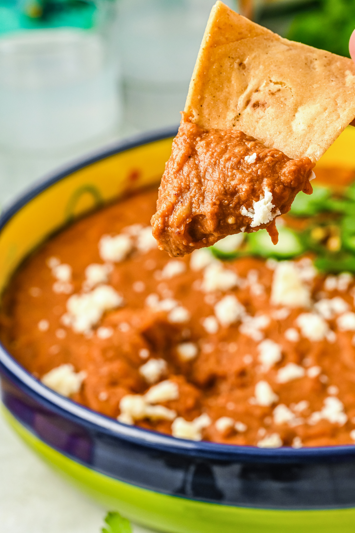 Frijoles puercos with queso fresco and cilantro on a tortilla chips. 