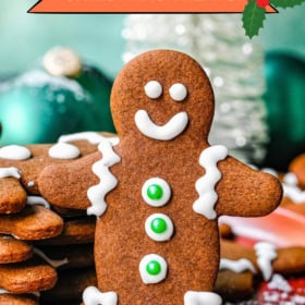 A plate of gingerbread men cookies stacked on top of each other.