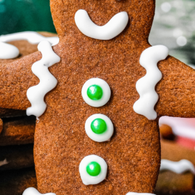 Gingerbread man cookie with icing and green sprinkle buttons.