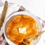 Overhead shot of a plate of hot cakes butter and syrup.