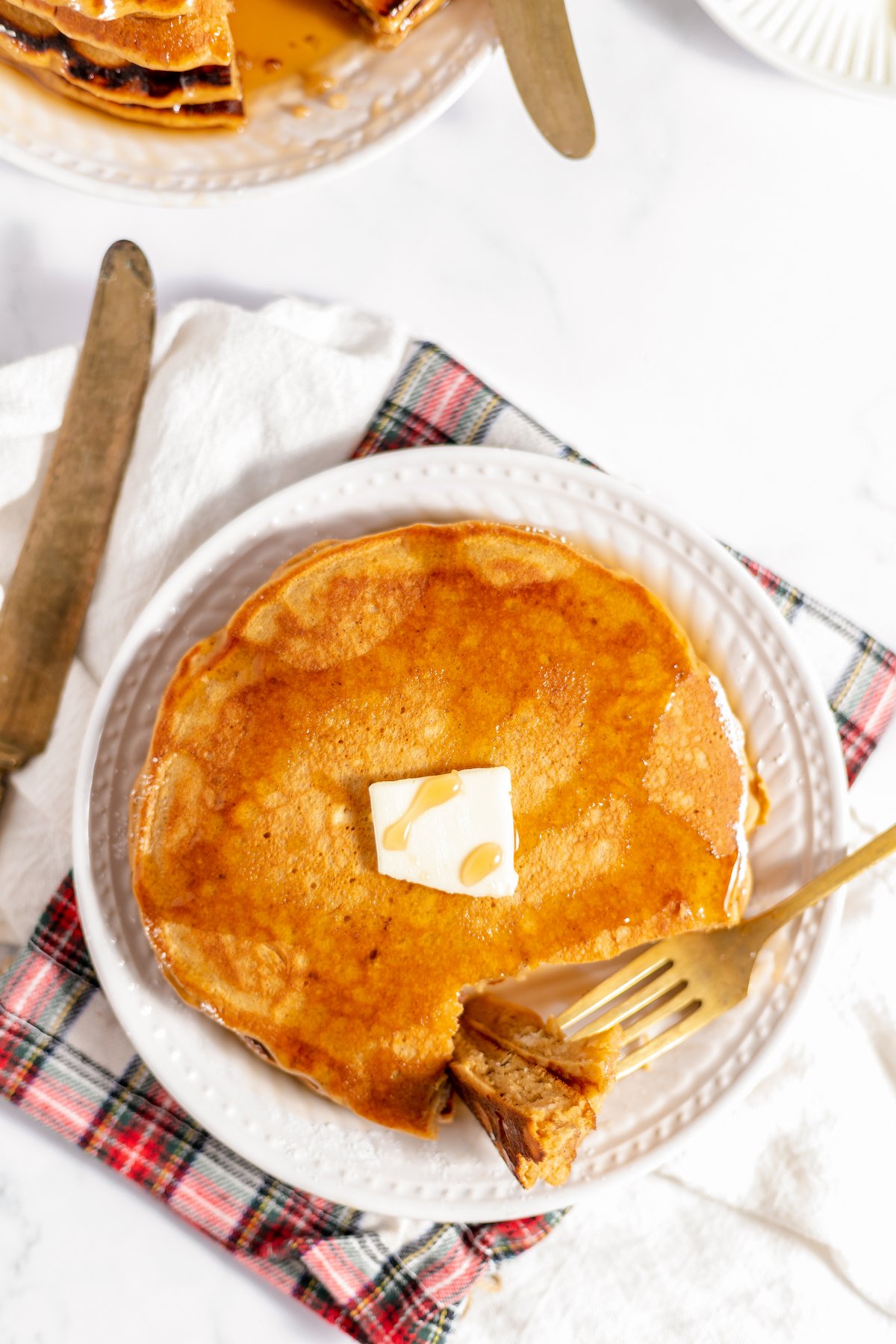 Overhead shot of a plate of hot cakes butter and syrup.