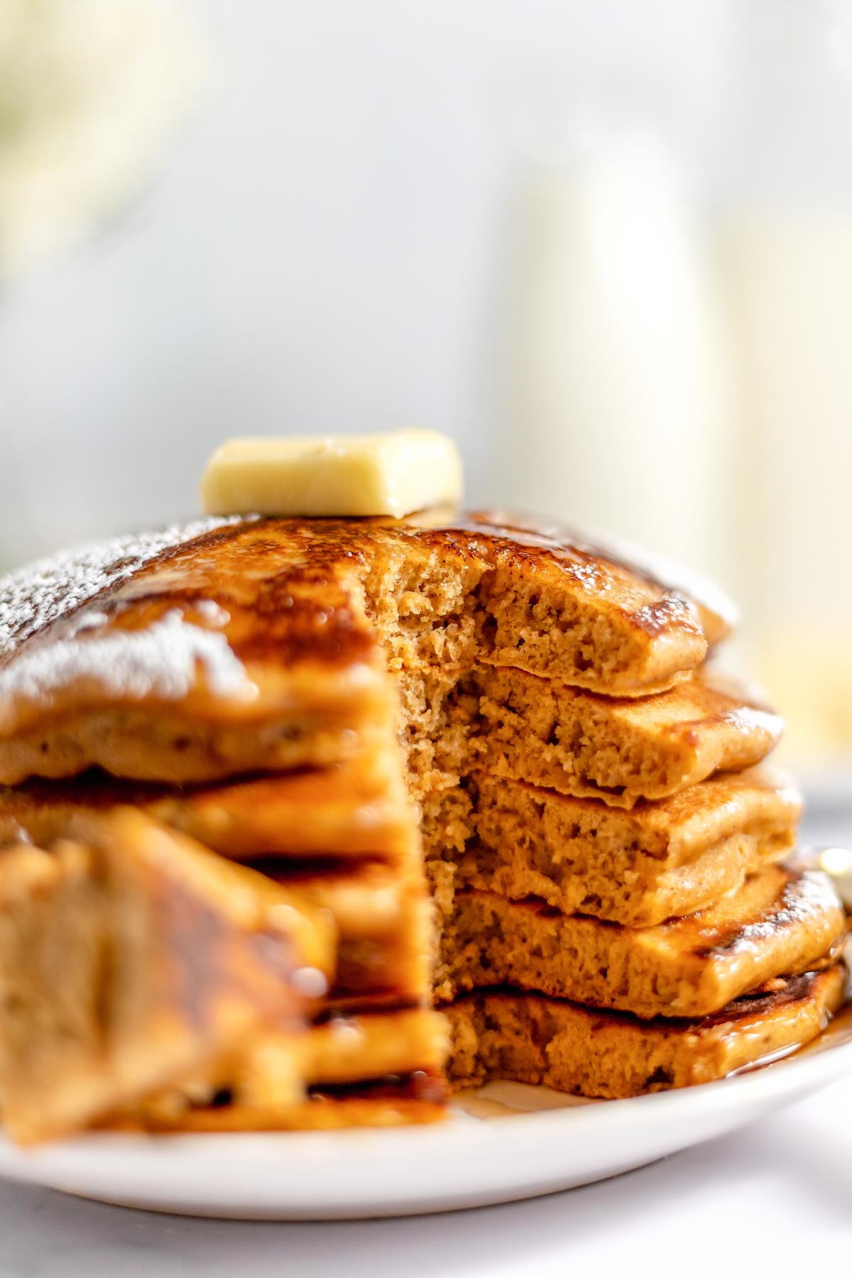 A stack of gingerbread hot cakes with a bite cut from the whole stack.