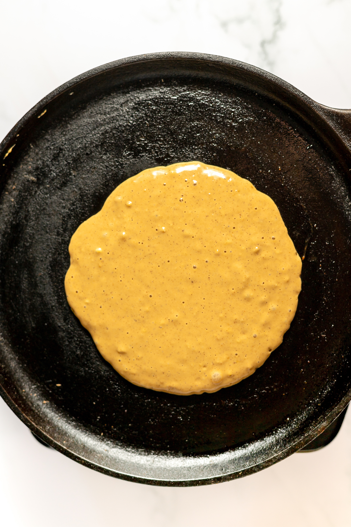Cooking a pancake on a cast-iron griddle.