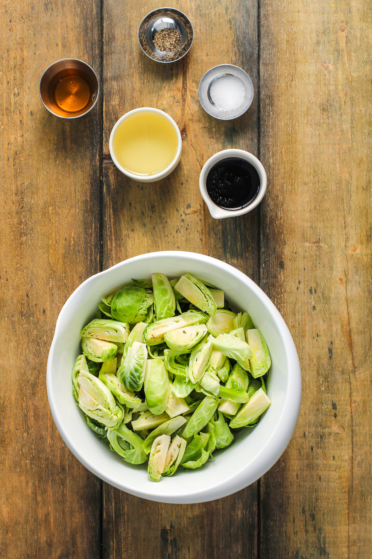 From top: Salt and pepper, honey, oil, balsamic glaze, quartered brussels sprouts.