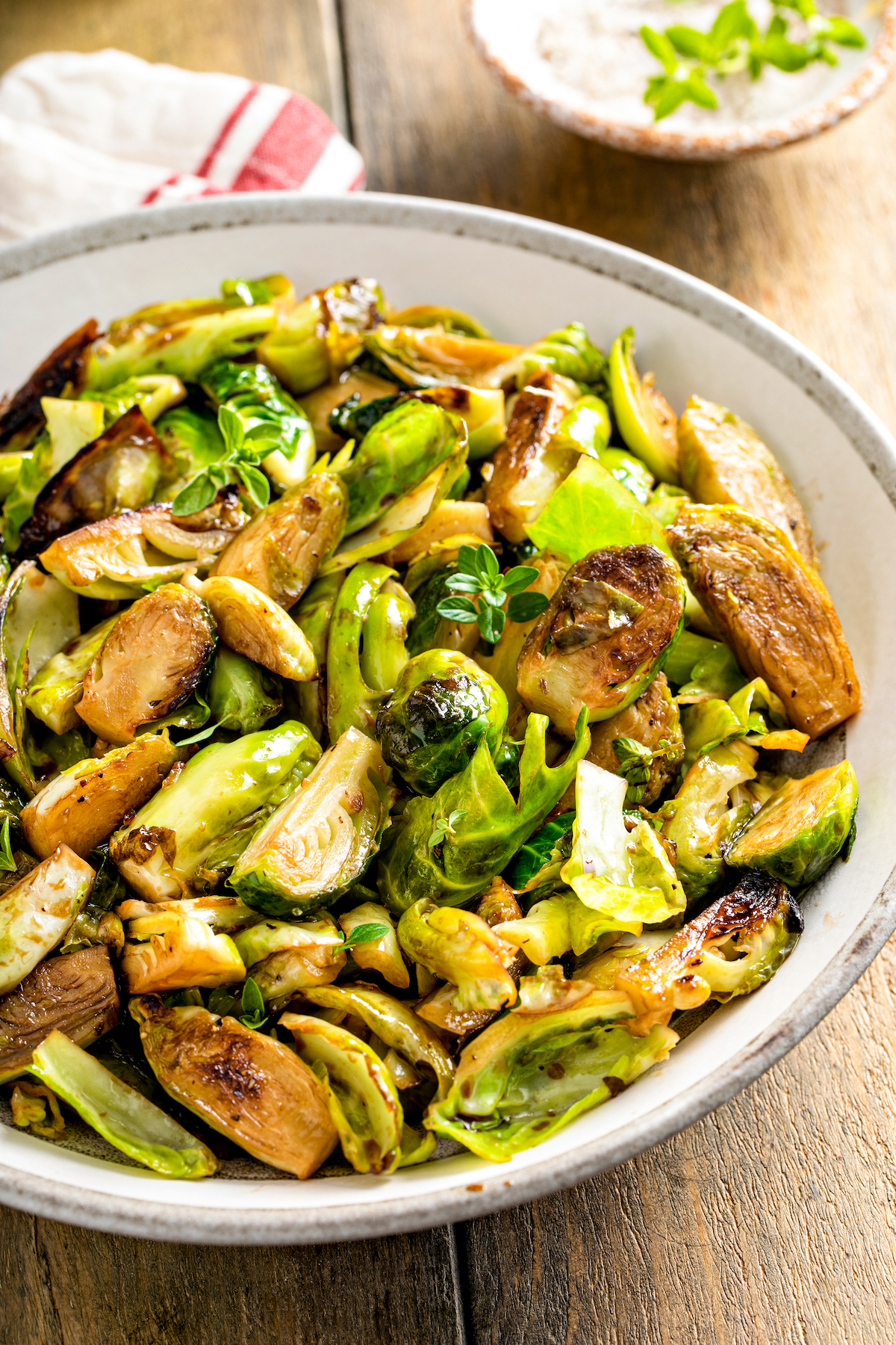 A large serving bowl filled with quartered sauteed sprouts.