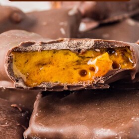 Chocolate dipped toffee candy pieces with once bitten in half to see the toffee center.