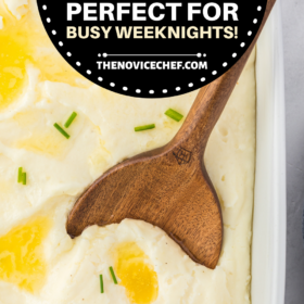 Mashed potatoes with melted butter on top with a wooden spoon.