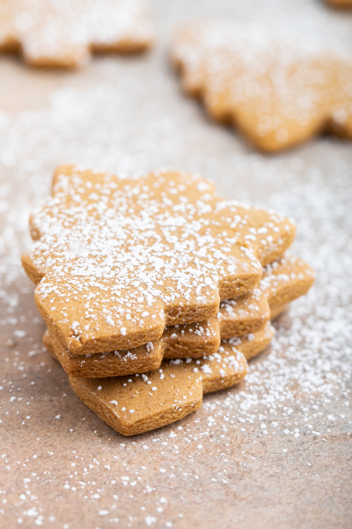 Three molasses cookies dusted with powdered sugar and stacked on top of each other.