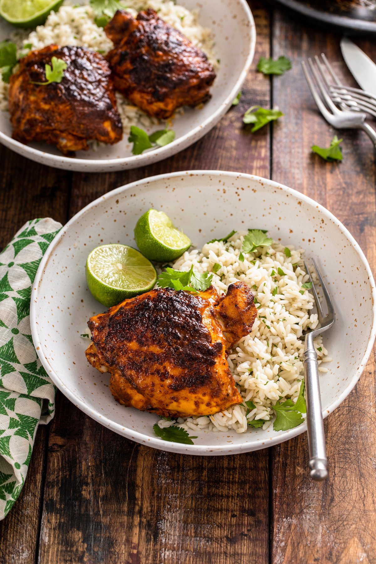 Pollo asado with rice, cilantro, and lime wedges.