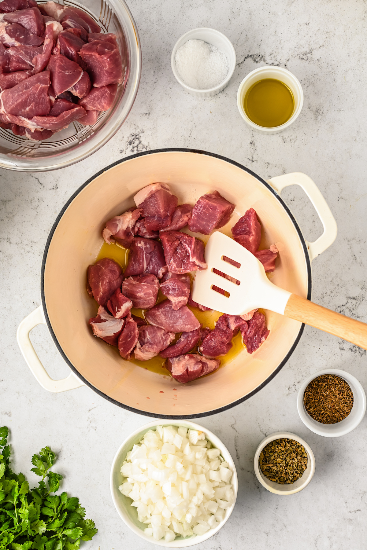 Placing the pork shoulder in the pot. 