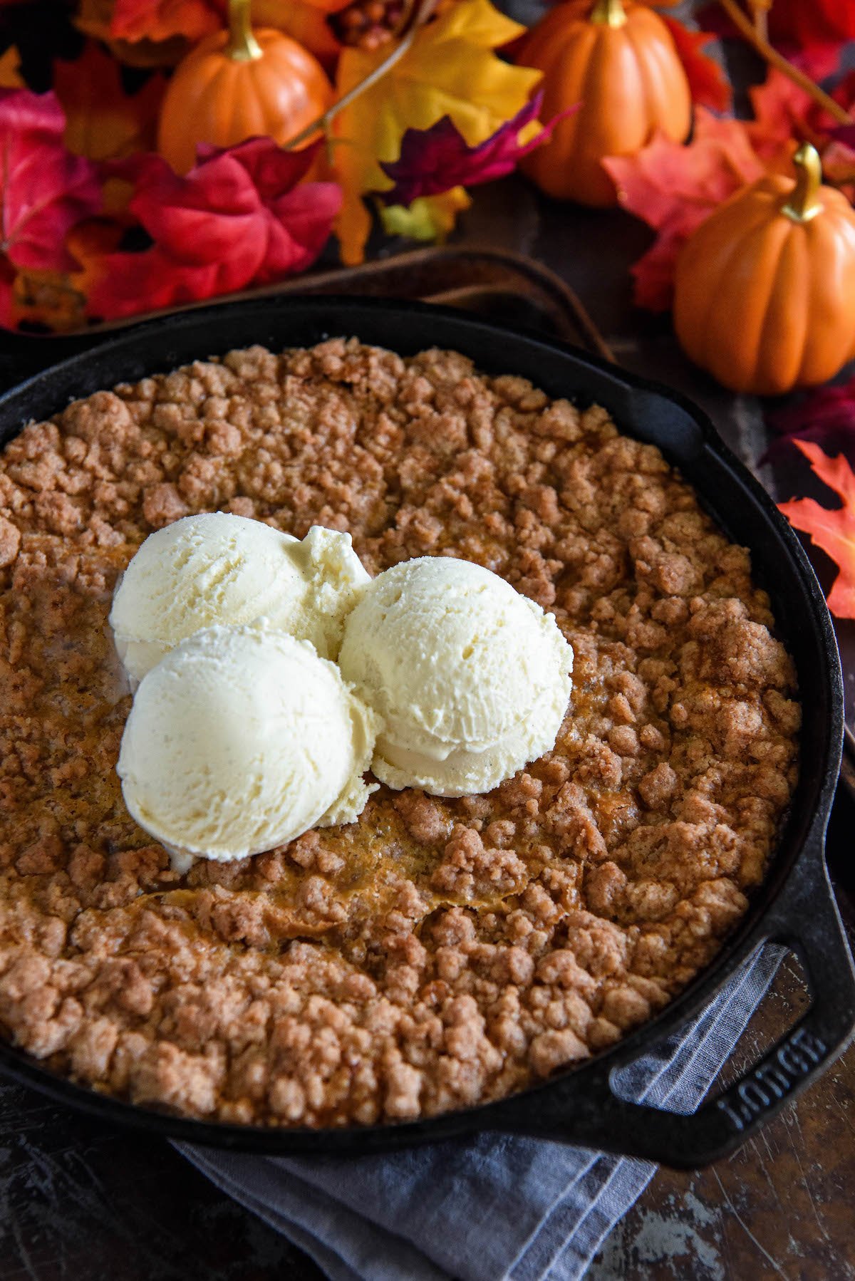 Three scoops of vanilla ice cream on top of a pumpkin crisp.